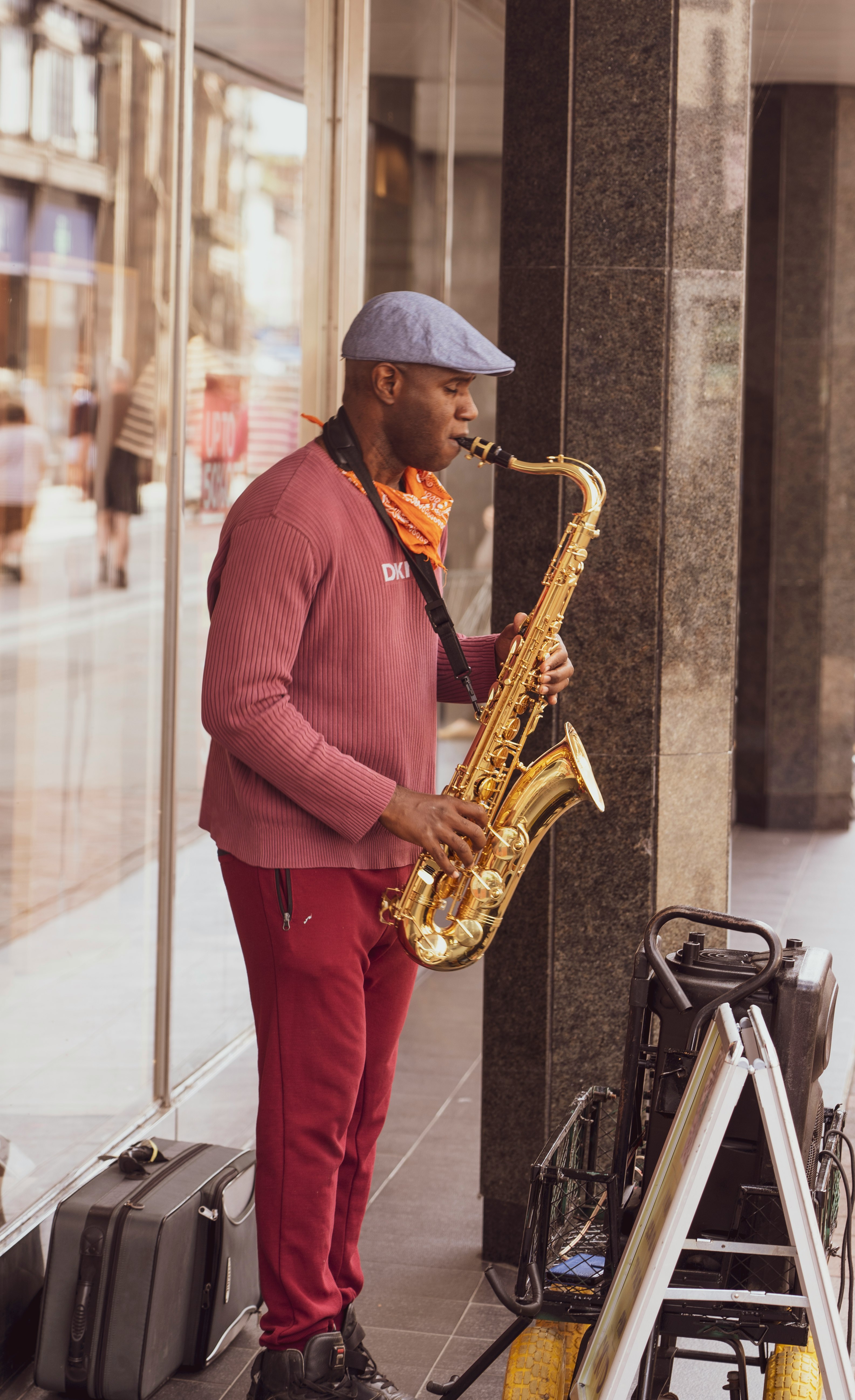 man in red dress shirt playing saxophone